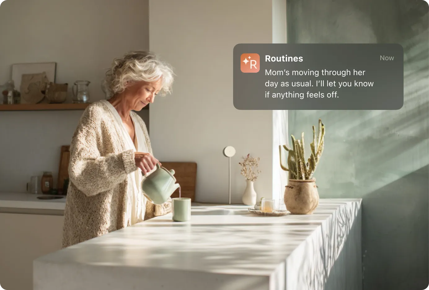 An older woman pours tea in a sunlit kitchen with a white sensor on the wall to her left, while a Routines app notification assures that her day is progressing normally and promises updates if anything changes.
